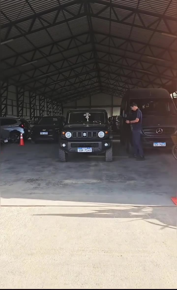 Sector techado del parking con autos guardados y un empleado junto a una camioneta